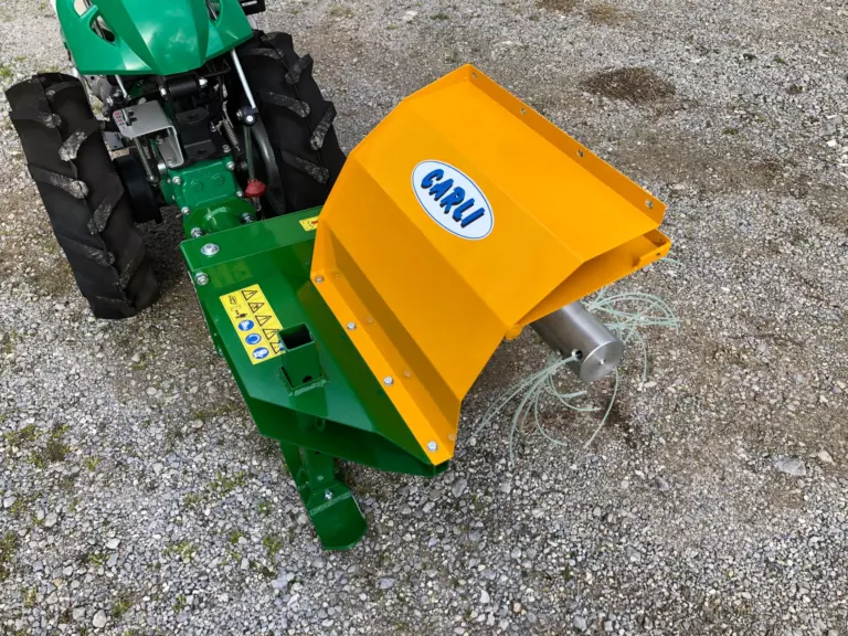 La decespugliatrice DT300 vista dall’alto, montata sul motocoltivatore verde, con il carter giallo e il logo Carli.
